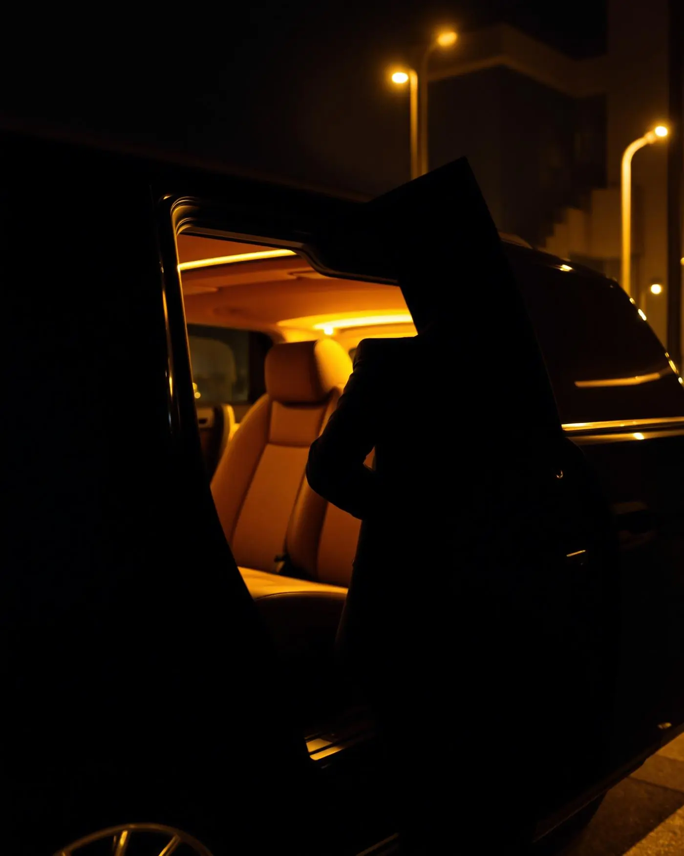 Boston chauffeur in a black suit opening the rear door of a luxury sedan